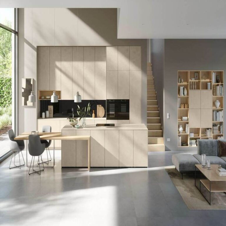 Offene moderne Küche in Beige mit Kochinsel, Essplatz und angrenzendem Wohnbereich – Küchenstudio Bergisch Gladbach